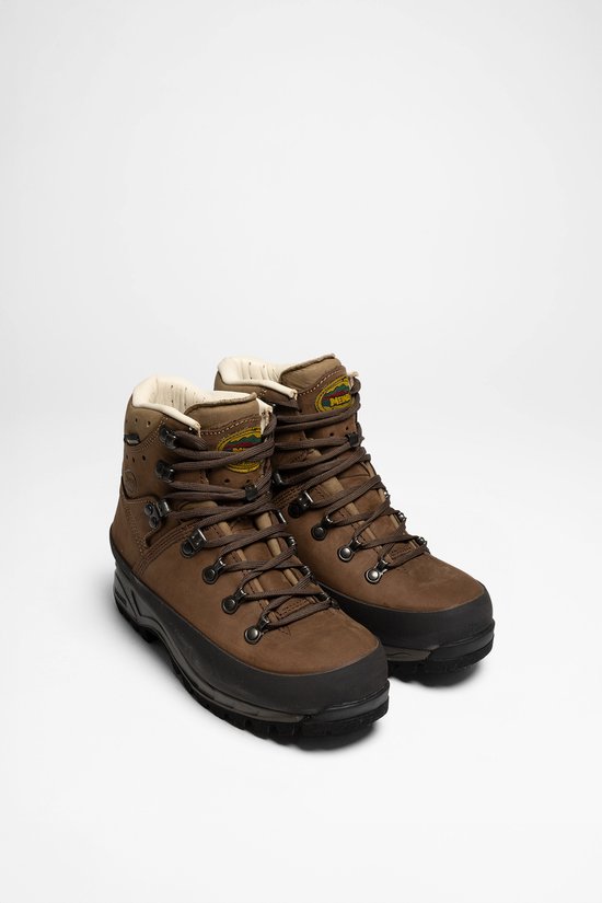 Une paire de chaussures de randonnée Meindl marron pour femme, avec lacets, logo Gore-Tex et inscriptions de la marque, sur fond blanc.