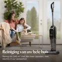 Zwarte BISSELL CrossWave stofzuiger met dweilfunctie, in een woonkamer, met twee vrouwen op de bank.