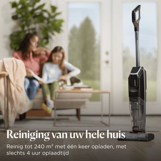 Zwarte BISSELL CrossWave stofzuiger met dweilfunctie, in een woonkamer, met twee vrouwen op de bank.
