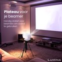 Een witte beamer op een zwart Lumina statief projecteert op een groot scherm in een woonkamer.