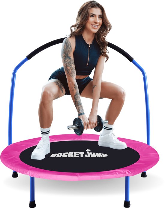 Vrouw met tattoos op trampoline, met roze mat, zilveren halter in handen.