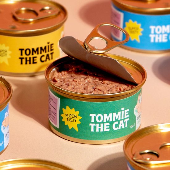 Open blikje kattenvoer met groene wikkel, 'Tommie the Cat Super Tasty'.