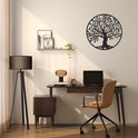 L'arbre de vie en métal noir est suspendu à un mur au-dessus d'un bureau avec un ordinateur portable et une chaise de bureau.