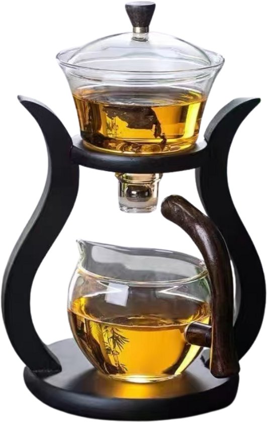 Glazen theezetapparaat met houten standaard, filter en glazen kan gevuld met goudkleurige thee.
