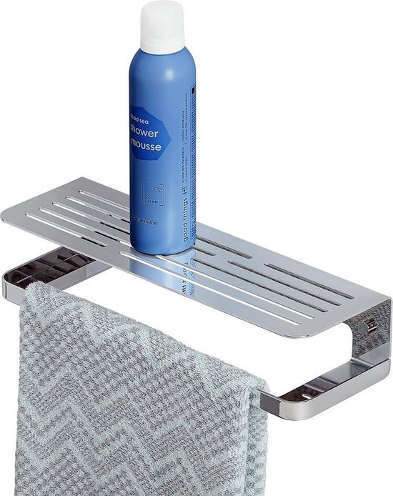 Étagère de douche Tiger chromée avec porte-serviette, une bouteille bleue et une serviette grise à motif zigzag.