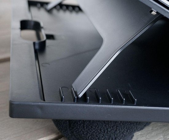Détail du dessous d'un coussin noir pour ordinateur portable avec des supports dépliables.