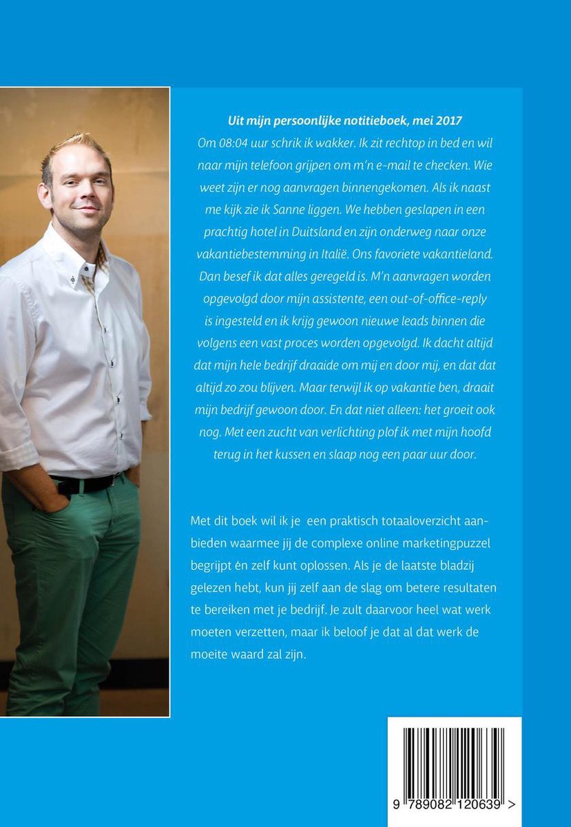Man in wit overhemd en groen broek, glimlacht, staand naast de achterkant van het boek 'De Online Marketing Machine'.