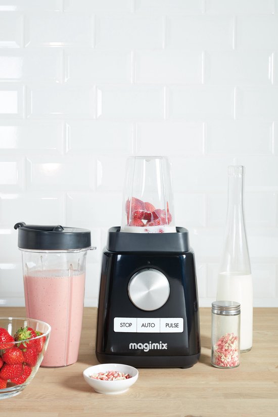 Zwarte Magimix blender met aardbeien en melk, naast een glas aardbeiensmoothie.