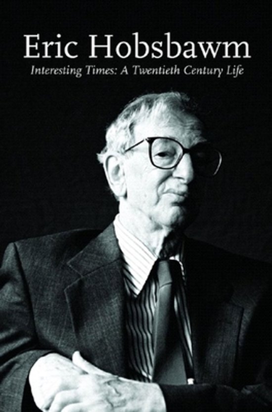 Portrait d'Eric Hobsbawm, portant des lunettes, une chemise à rayures, une cravate et un costume.