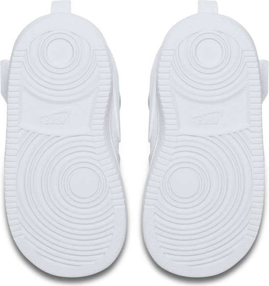 Onderkant van twee witte Nike sneakers met cirkelvormig profiel.