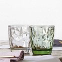 Un verre transparent et un verre vert avec un motif à facettes.