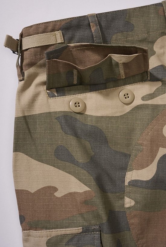Detail van camouflage broek met klepzakken en knopen, beige band met gesp.