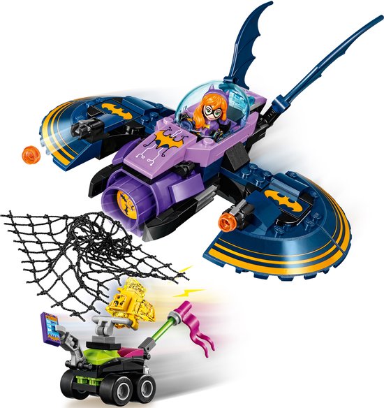 Paarse en donkerblauwe Batgirl batjet met vleermuisvleugels en een net dat een groen voertuig met gele vleermuis vangt.
