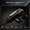 Zwarte tondeuse met zilverkleurige knop en USB-kabel, naast 2 opzetstukken.