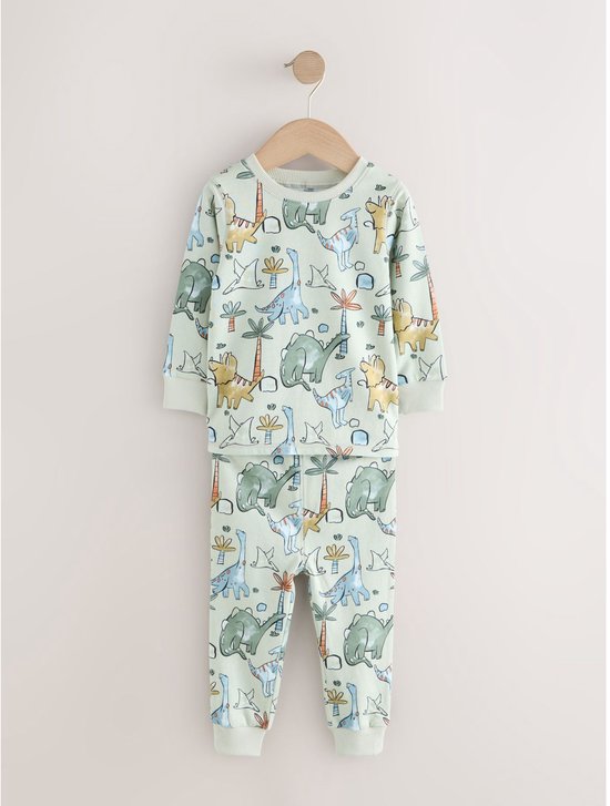 Lichtgroene pyjamaset met all-over dinosaurus- en palmboomprint.