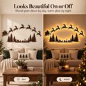 Houten kerstdecoratie met de slee van de kerstman en rendieren. Toont het ontwerp overdag en met warme verlichting 's nachts.