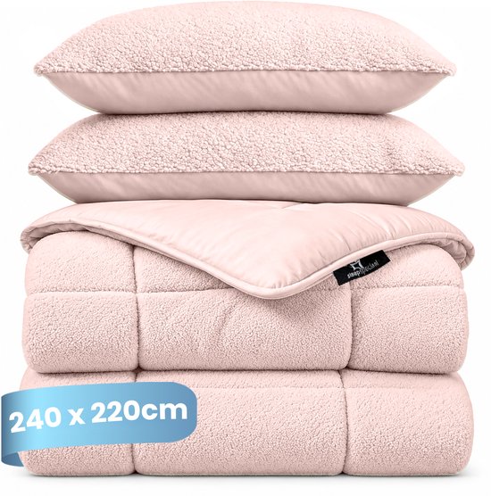 Een roze teddy dekbed (240x220cm) gestapeld met twee kussens, het bovenste kussen is roze satijn.