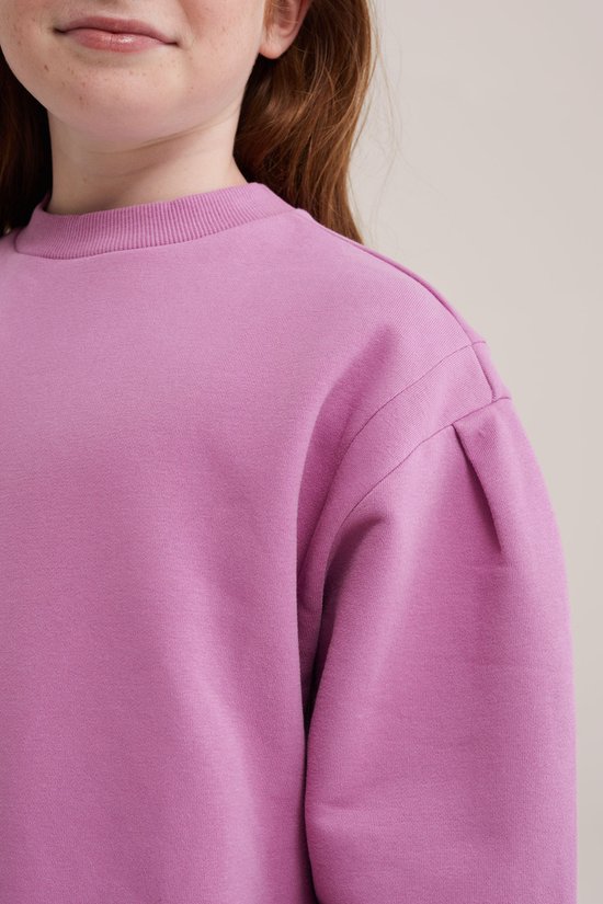 Roze sweaterjurk voor meisjes met pofmouwen en ronde hals, gedragen door een kind.