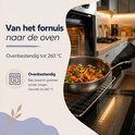 Geroosterde kip en groenten in een koekenpan worden uit een oven gehaald.