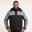 Man met een Tricorp werkparka in zwart en grijs, met reflecterende strepen.