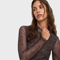 Close-up van model in bruine mesh top met hartjesprint en hoge hals.