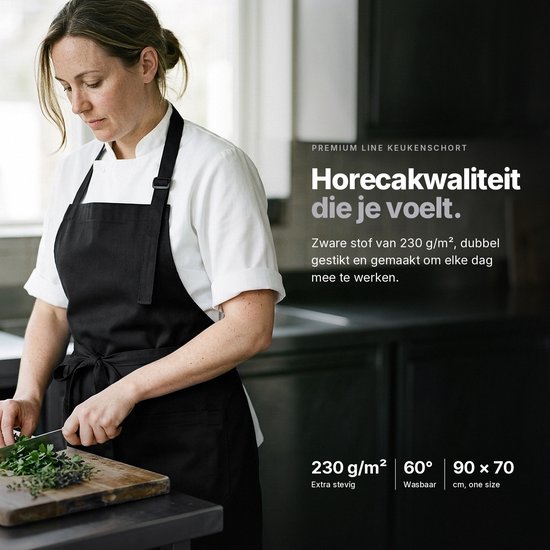 Een chef-kok met een zwart Viamart® premium schort, tijdens het koken. Het schort is 90 x 70 cm, wasbaar op 60°.
