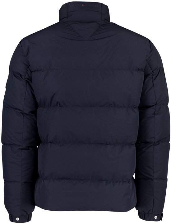 Achterkant van een donkerblauwe gewatteerde jas met een subtiel Tommy Hilfiger-label bij de kraag.