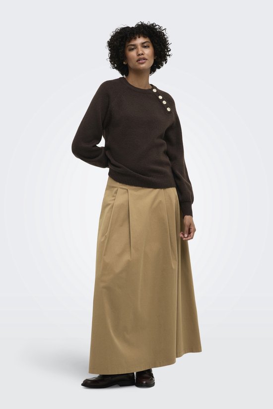 Bruine gebreide trui met gouden knopen, gedragen door een vrouw met een beige rok.