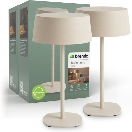 Twee beige oplaadbare tafellampen van het merk Brendz, model Nuna, naast een verpakking. De lampen zijn dimbaar en USB-oplaadbaar.