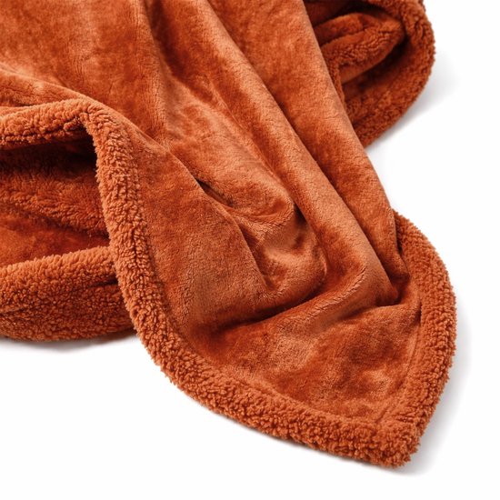 Een oranje terra plaid van fleece met een teddy rand, zacht en warm.