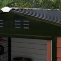 Detail van de donkere dakrand van een tuinhuis met ventilatieroosters.