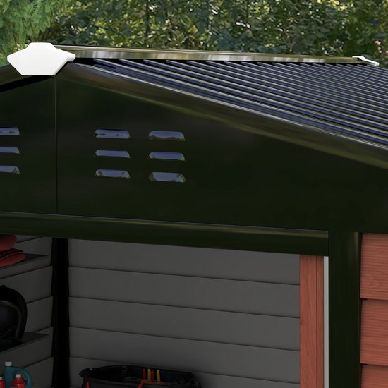Detail van de donkere dakrand van een tuinhuis met ventilatieroosters.
