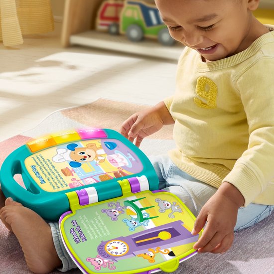 Een jongen met een gele trui speelt met een open, felgekleurd Fisher-Price 'Verhalenboek Versjes' met een afbeelding van een muis.