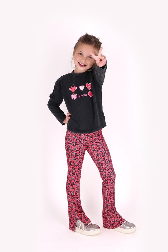 Meisje draagt een zwarte sweater met 'B.NOSY' en hartjes, gecombineerd met een rode flared broek met bloemenpatroon.