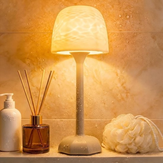Waterdichte tafellamp met watereffect in een badkamer, naast een zeepdispenser, geurstokjes en een badspons.