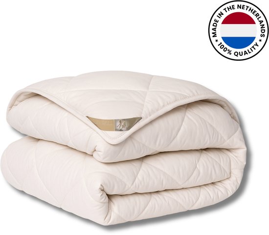 Opgevouwen off-white wollen dekbed met ruitpatroon en Ten Cate label, inclusief zegel 100% kwaliteit uit Nederland.
