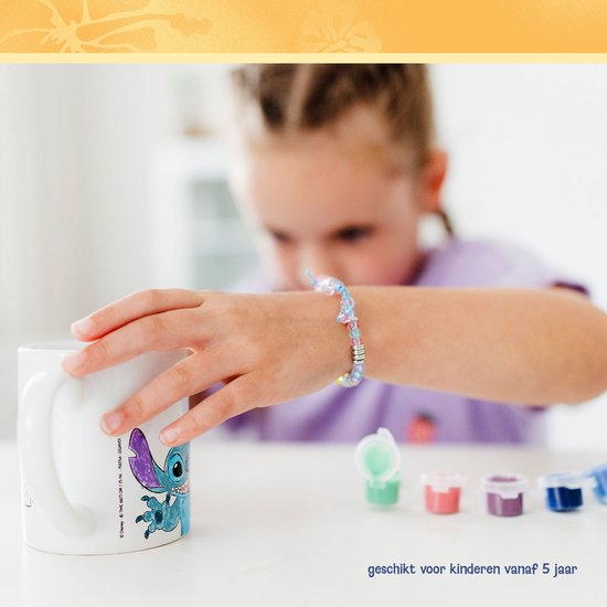 Kind reikt naar een geschilderde Stitch mok, tekst: geschikt voor kinderen vanaf 5 jaar.