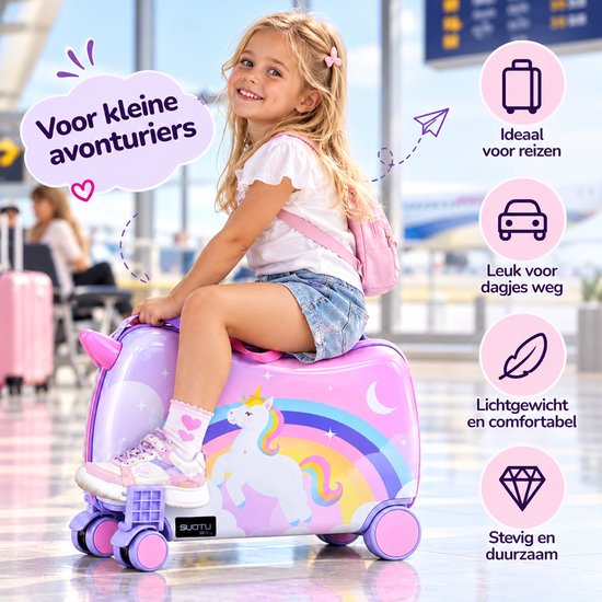 Lachend meisje op een roze eenhoorn-koffer met regenboog, voorzien van voetsteunen in een luchthaven.