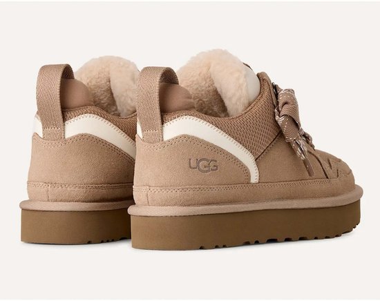 Aanzicht van de achterkant van twee lichtbruine UGG Lowmel sneakers met zichtbaar UGG-logo en witte accenten.