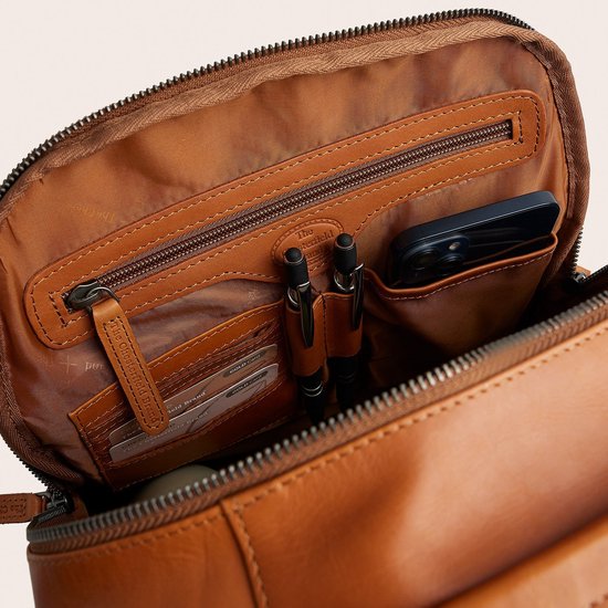 Binnenzijde van bruine lederen rugzak met vakken voor pasjes, pennen en smartphone, 'The Chesterfield Brand' logo.
