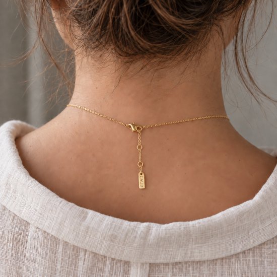 Achterkant van een gouden ketting met een verstelbare sluiting en een klein plaatje met het GAUD logo.