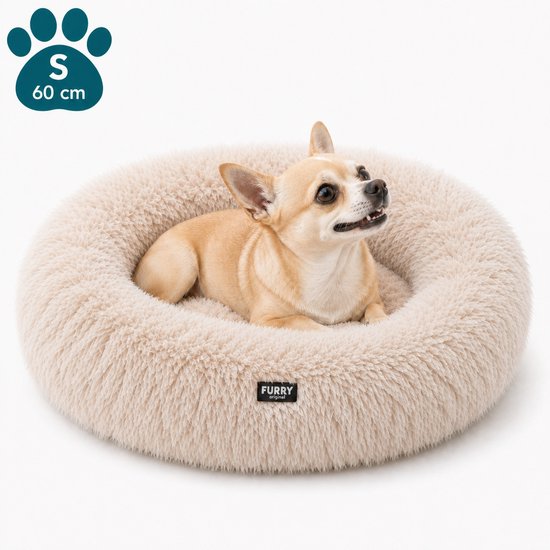 Un petit chihuahua clair repose dans un lit rond pour chien beige et pelucheux de Furry Original avec un bord surélevé. Le lit a un logo patte 'S 60 cm'.
