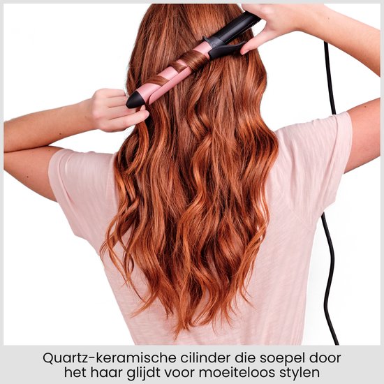 Achterkant van vrouw met rood haar die haar haar krult met een rose-gouden krultang.