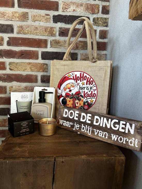 Kerstpakket met een jute tas met kerstman, een houten bordje met tekst, zeeppompje, mok en een geurkaars.