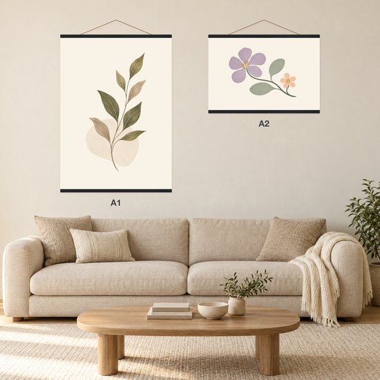 Woonkamer interieur met een beige bank en twee zwart ingelijste botanische prints aan de muur.