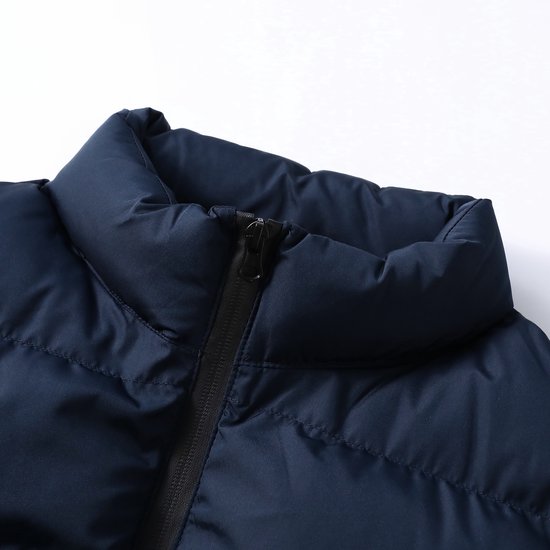 Detail van de donkerblauwe opstaande kraag met ritssluiting.