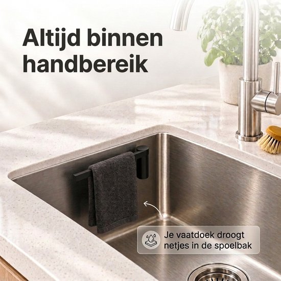 Zwarte vaatdoekhouder in een roestvrijstalen spoelbak, de vaatdoek droogt netjes uit het zicht.