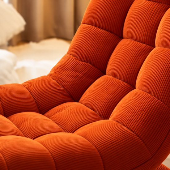 Close-up van de zachte, oranje corduroy bekleding met een gecapitonneerd ruitpatroon op de stoel.