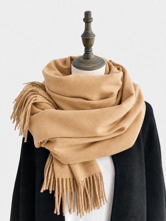 Camelkleurige imitatiekasjmier sjaal met franjes, gedrapeerd om een zwarte cape.