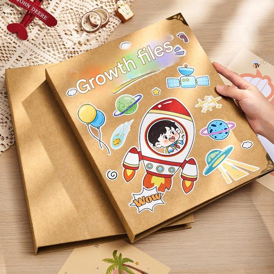 Bruin fotoalbum 'Growth files' met stickers van een raket, planeten en een kind in de ruimte.